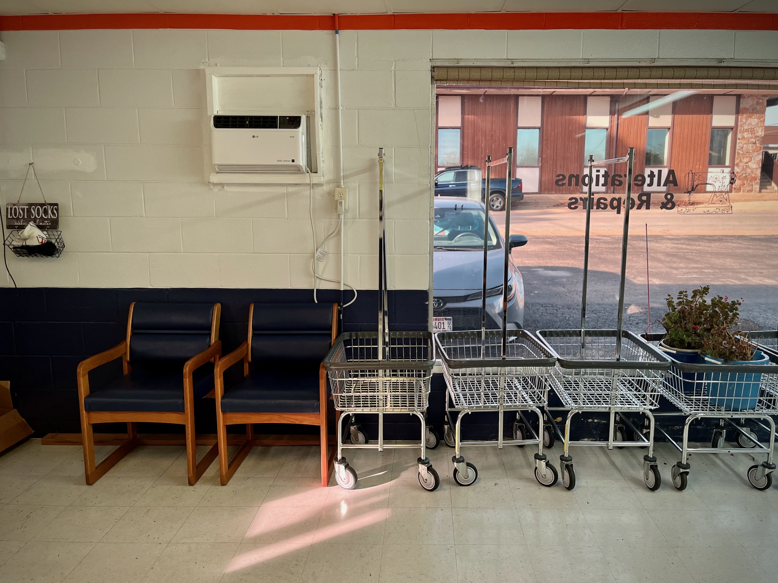 Interior of Poly Clean Center laundromat with chairs and laundry carts in afternoon light